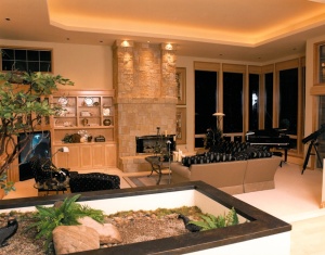 Example of custom interior lighting around the masonary of a fireplace and an inside garden.